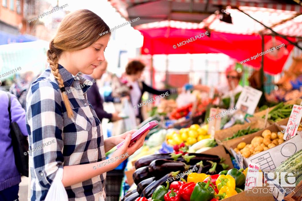 Stock Photo: young woman reading her shopping list.