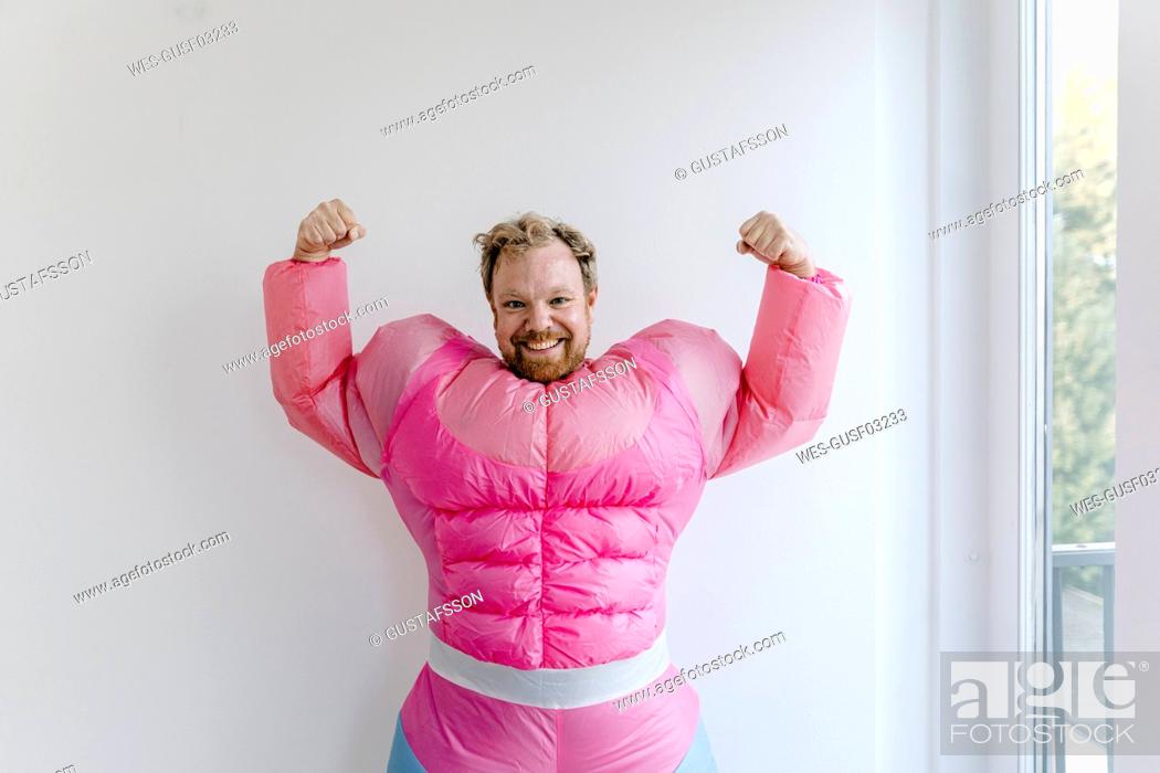 Stock Photo: Proud man wearing pink bodybuilder costume flexing his muscles.
