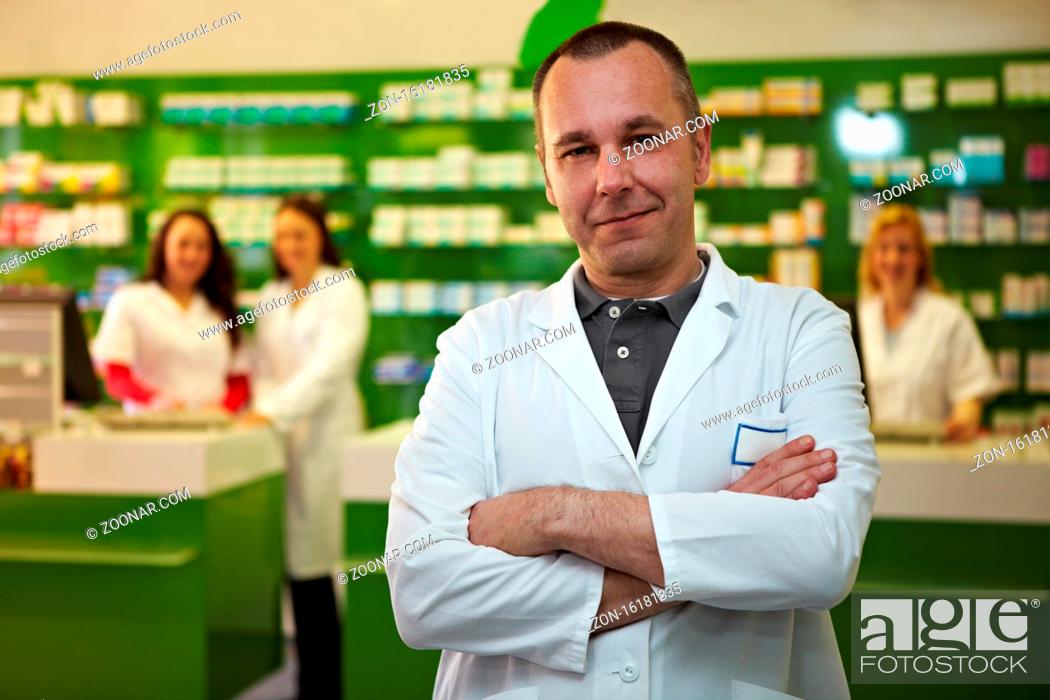 Stock Photo: Apotheker steht mit seinem PTA-Team in einer Apotheke.