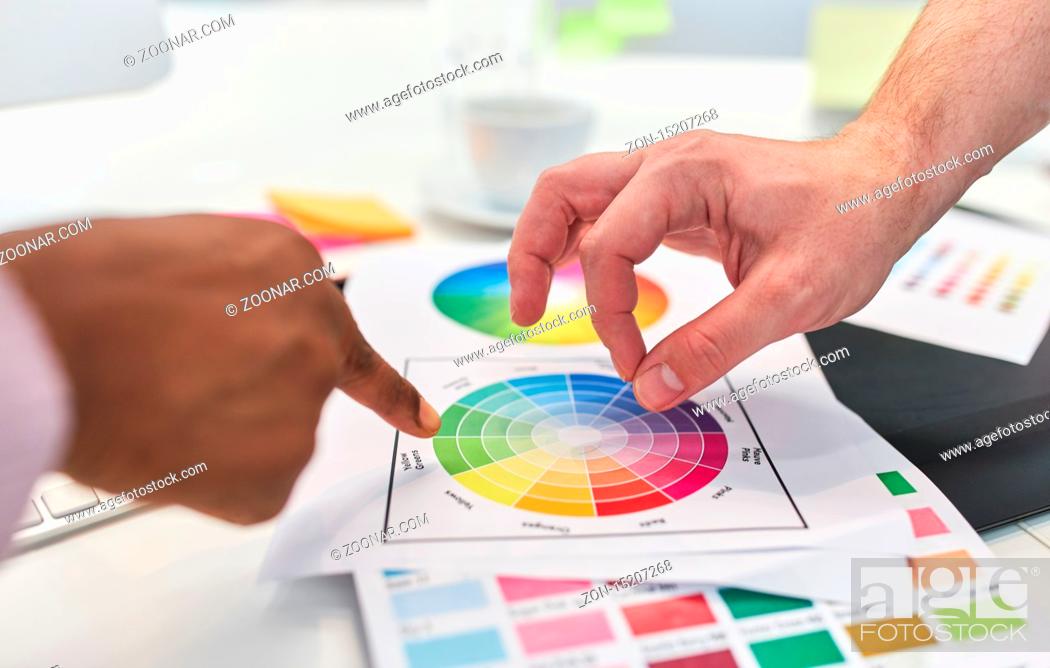 Stock Photo: Hände von zwei Grafikdesignern zeigen auf Farbpalette beim Brainstorming.