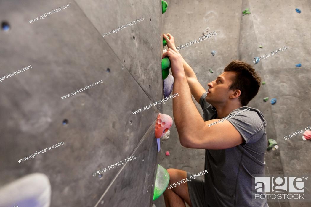 Stock Photo: young man exercising at indoor climbing gym.