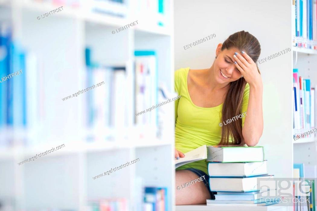 Imagen: Cute female university/highschool student with books in library.