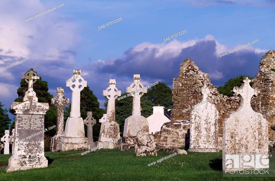 Stock Photo: Monolithic high crosses and O'Rourke's Tower in the monastic complex on the banks of the River Shannon, Clonmacnoise, Ireland.