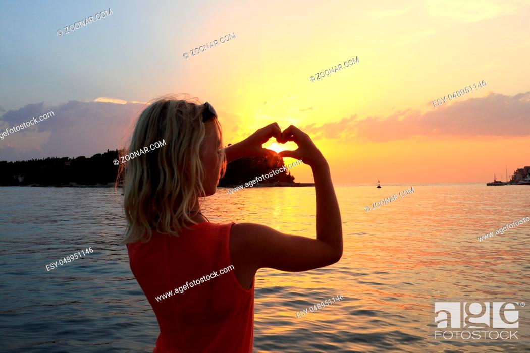 Photo de stock: Mädchen mit Herzsymbol am Hafen.