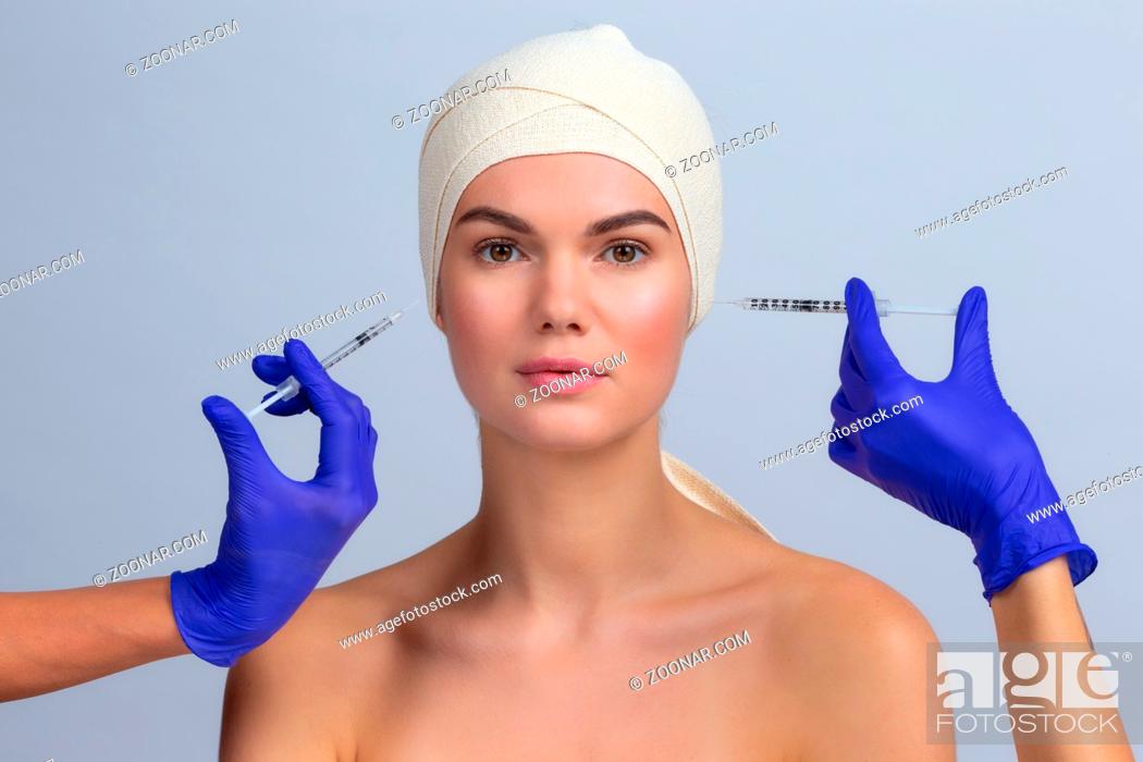 Stock Photo: Beautiful woman gets injection in her face beauty treatment concept.