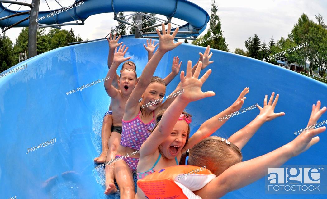 Stock Photo: Children slide down the 75 m long waterslide in the bath of Rebesgruen, Germany, 24 July 2013. This weekend the 17th German water sliding championship will take.