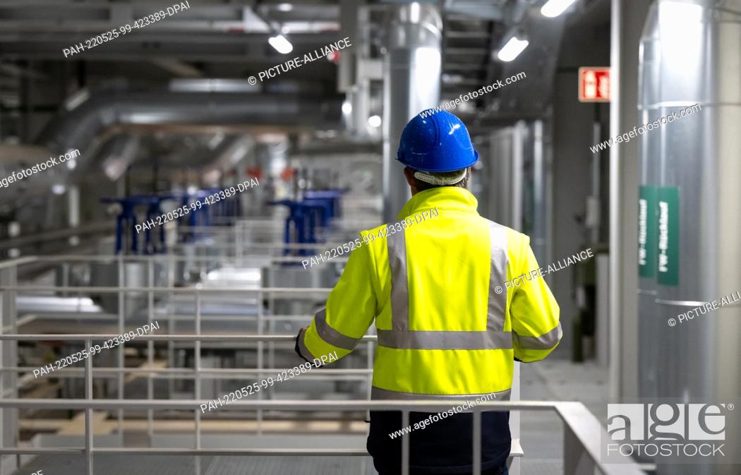 Stock Photo: 24 May 2022, Bavaria, Munich: An employee of Stadtwerke München stands in the geothermal plant at Heizkraftwerk Süd. Stadtwerke München's geothermal plant.