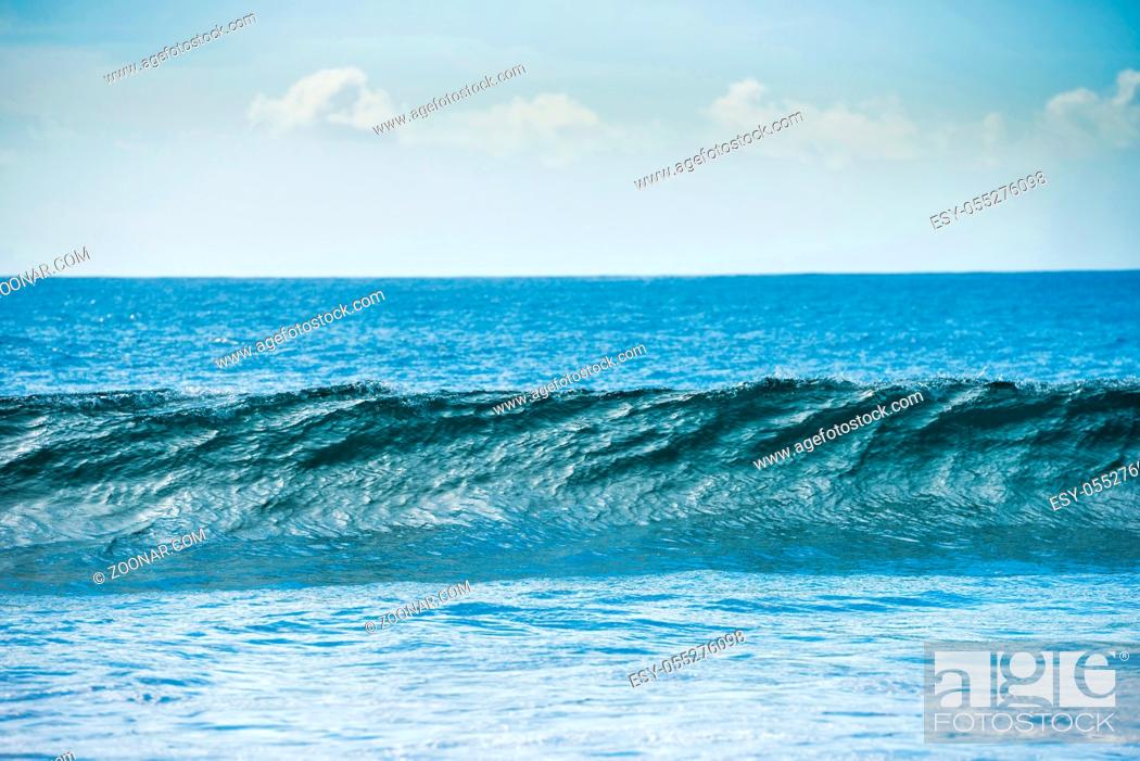 Imagen: Calm blue seascape with white surf wave on foreground.