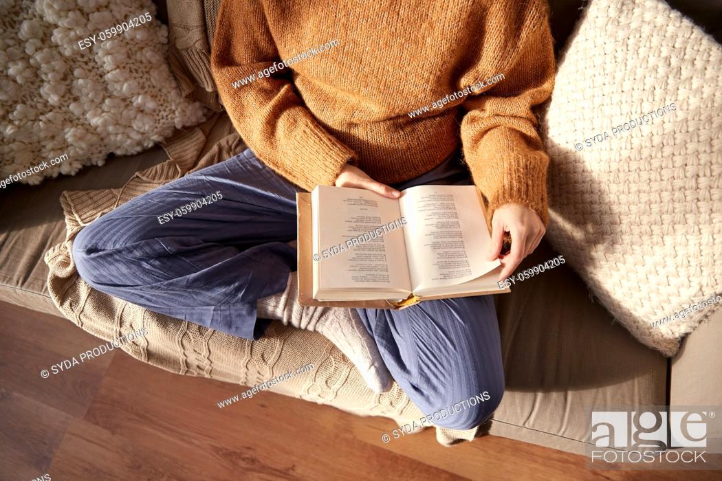 Stock Photo: woman in warm sweater reading book at home.
