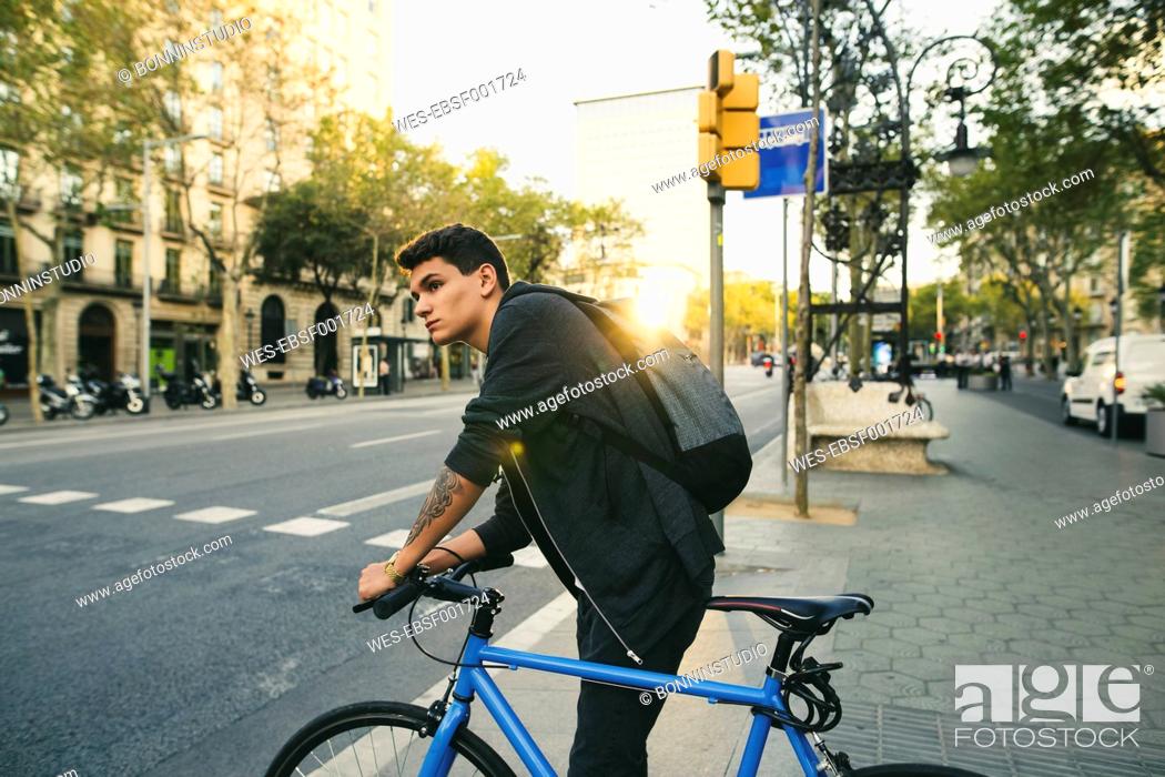 Stock Photo: Teenager with a bike in the city.