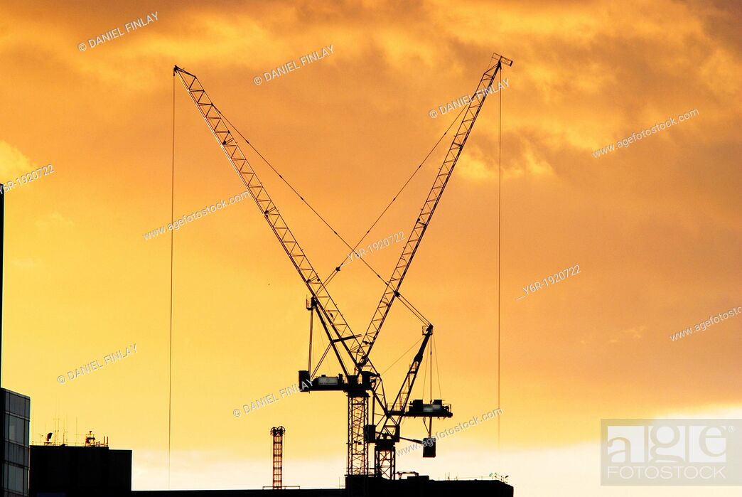 Stock Photo: Giant cranes on the South Bank of the Thames in London, England, caught in a Winter sunset.