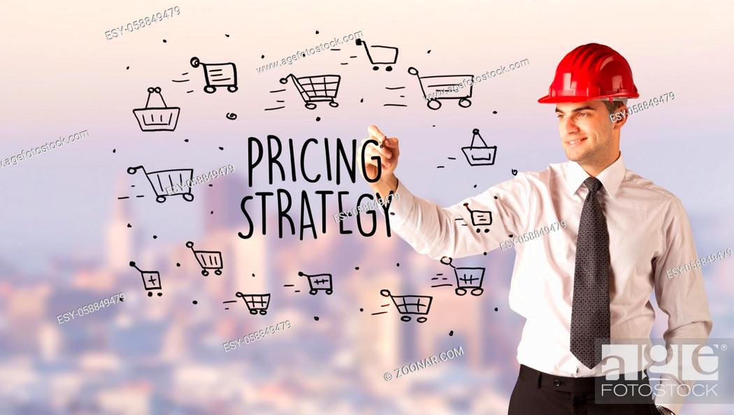 Stock Photo: Handsome businessman with helmet drawing PRICING STRATEGY inscription, contruction sale concept.