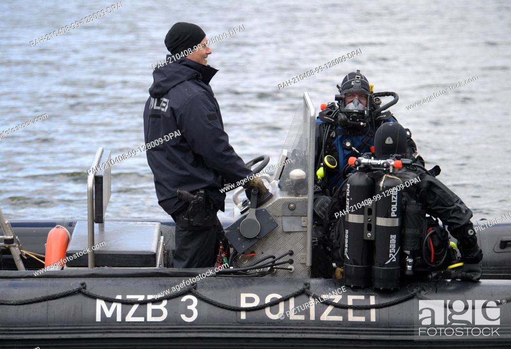 Stock Photo: 08 April 2021, Brandenburg, Flieth-Stegelitz/Gt Suckow: A rubber dinghy with divers of the Brandenburg police sails after the first dive on the Oberuckersee.
