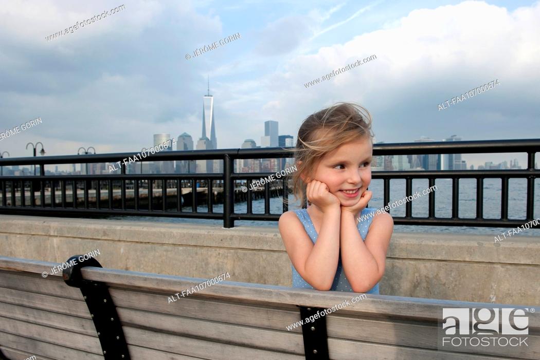 Imagen: Little girl resting on pier near New York City, New York, USA.