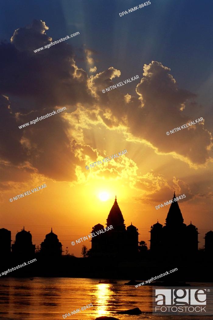 Stock Photo: Cloudy sunset with chhatries cenotaphs at bank of river Betwa , Orchha , Madhya Pradesh , India.