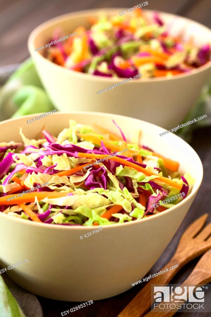 Stock Photo: Fresh coleslaw, a salad made of shredded red and white cabbage and carrots, served in white bowls, photographed with natural light (Selective Focus.