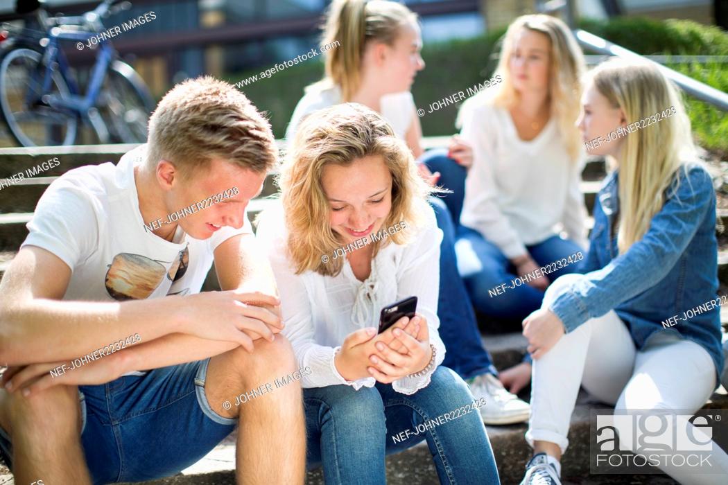 Stock Photo: Friends sitting on steps together.