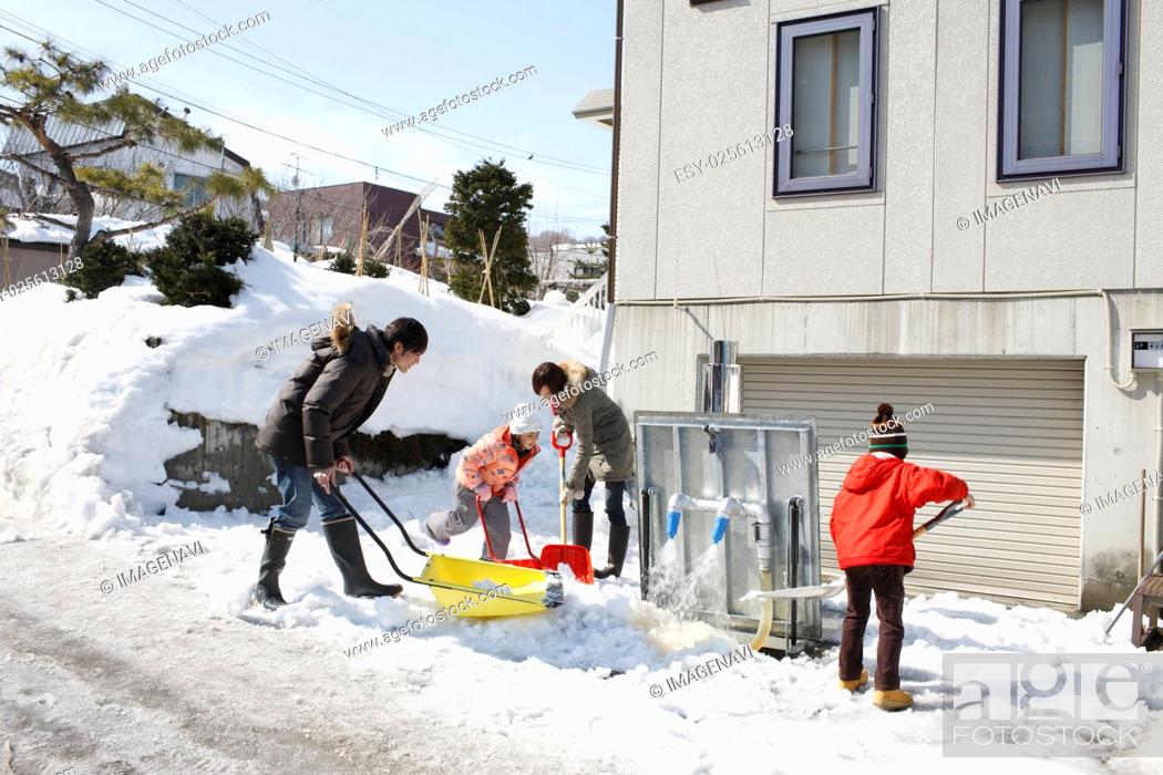 Stock Photo: Family removing snow.
