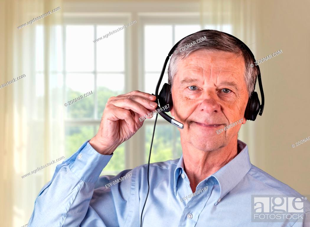 Photo de stock: Senior caucasian man using headset to talk to customers or team in work from home.