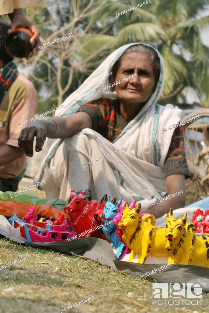 Stock Photo: Portrait of an old woman selling clay toys at a fair held during the Eid-ul-Adha festival in a village Mayshaghuni, Rupsha, Khulna, Bangladesh January 01.