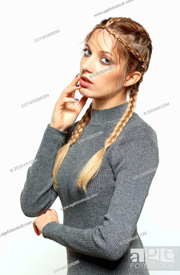 Stock Photo: Portrait of beautiful young dark blonde woman. Female with creative braid hairdo on gray background. Girl with hand near face.