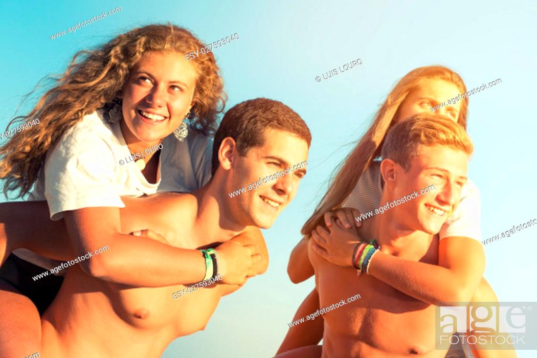 Stock Photo: Happy teenage couples playing at the beach.
