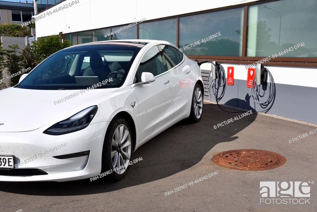 Stock Photo: 06 September 2020, Rhineland-Palatinate, Prüm: A Tesla Model 3 is charged at the charging station for TESLA electric vehicles, manufacturer of electric vehicles.