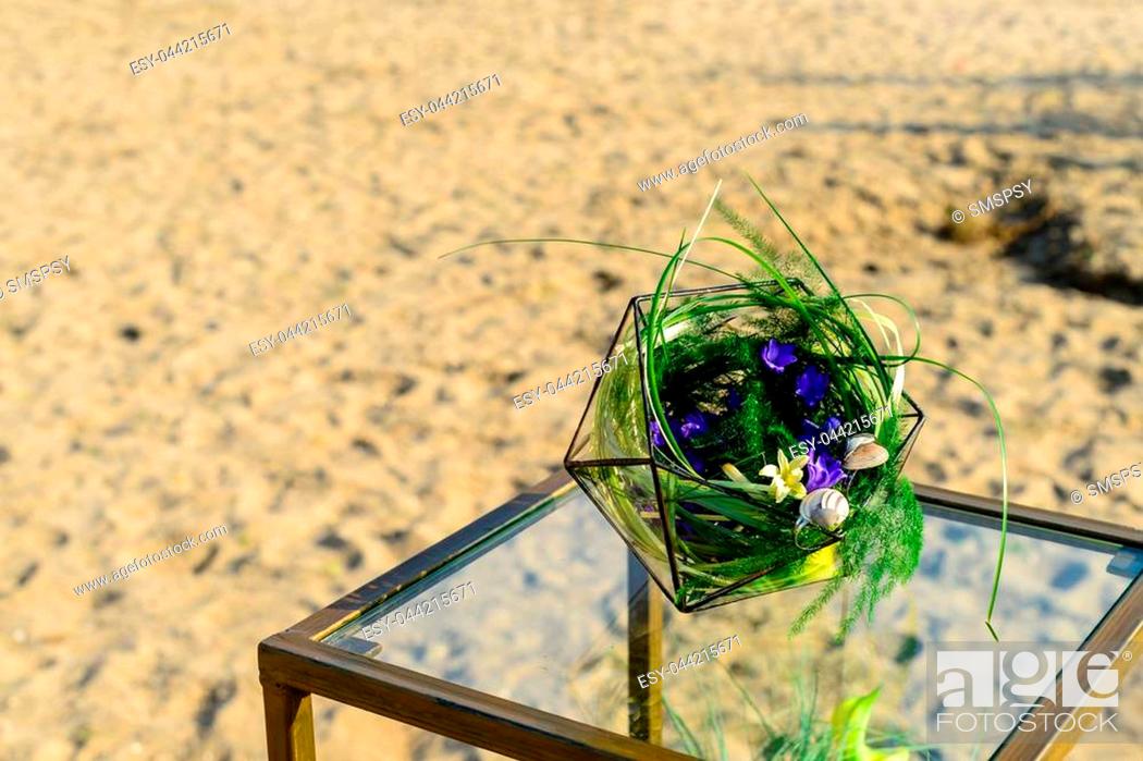 Stock Photo: Beautiful glass florarium glass with succulent plants on the table on the beach.