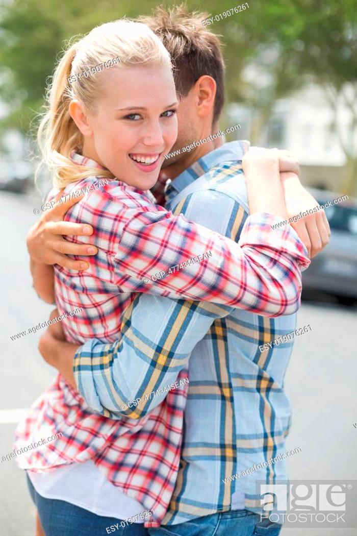 Stock Photo: Couple in check shirts and denim hugging each other.
