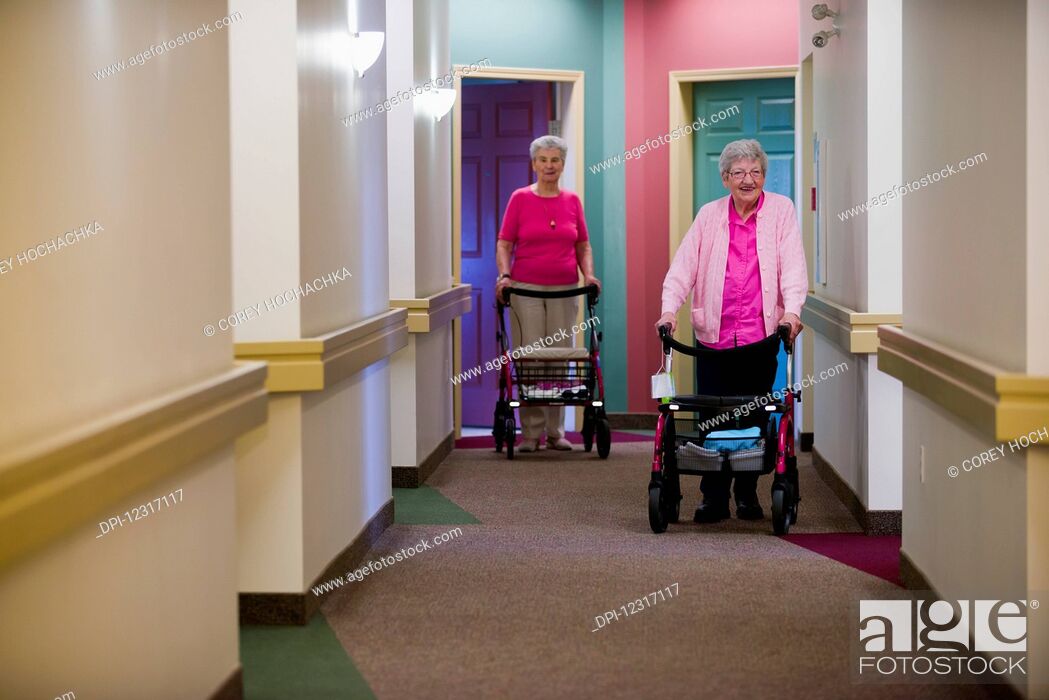 Stock Photo: Senior Citizens Walking Down Shared Residence Hallway; Devon, Alberta, Canada.