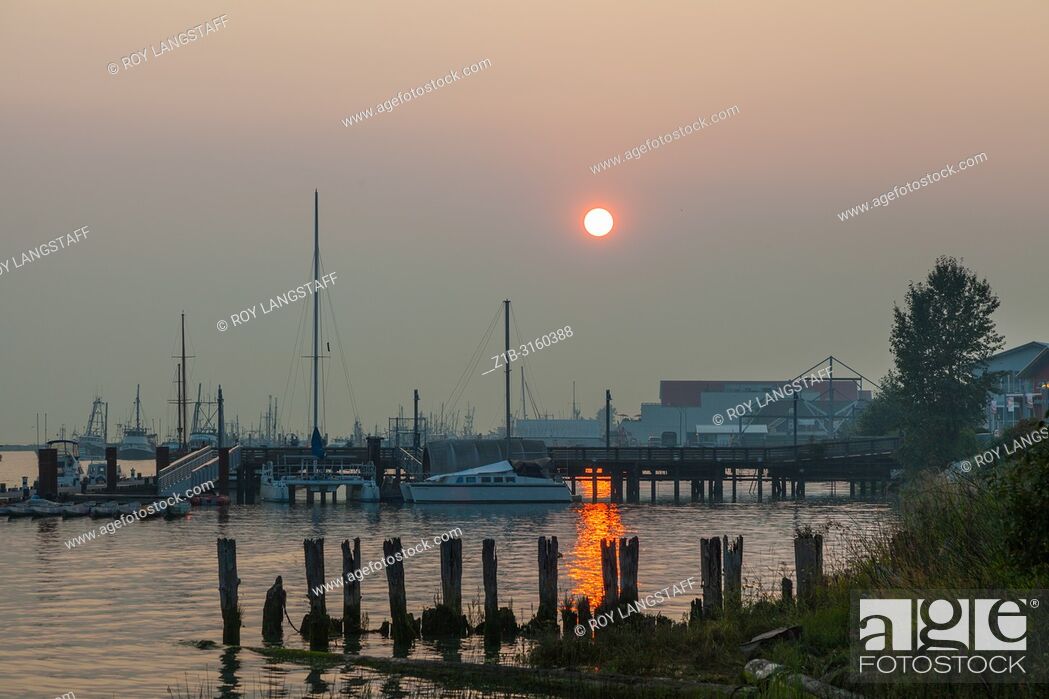 Stock Photo: Evening sun struggling to penetrate the forest fire smoke over Steveston, British Columbia.