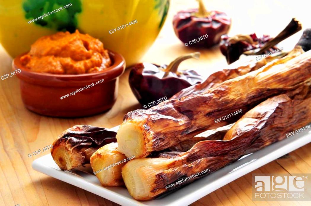 Stock Photo: barbecued calcots, catalan sweet onions, and romesco sauce.