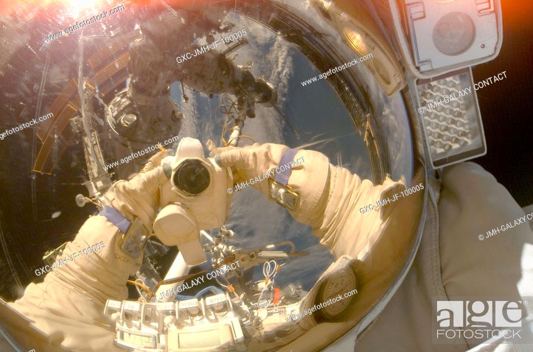 Stock Photo: Russian Federal Space Agency cosmonaut Oleg Kononenko, Expedition 17 flight engineer, uses a digital camera to expose a photo of his helmet visor during a.