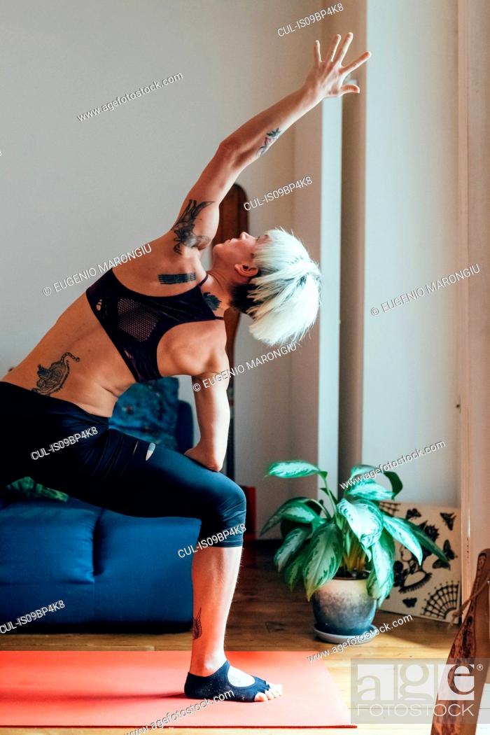 Stock Photo: Woman practising yoga at home.