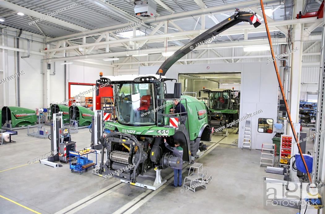 Stock Photo: Two employees mount a Fendt Katana 65 corn chopper in a former tank maintenance hall in Hohenmoelsen, Germany, 17 April 2015.
