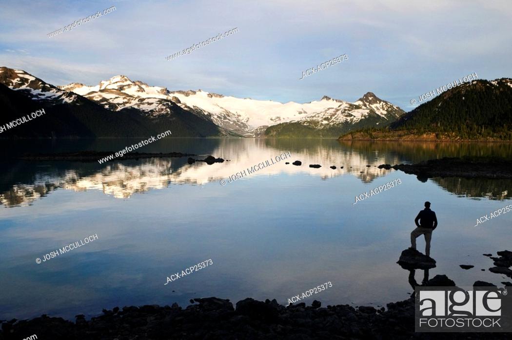 Stock Photo: A hiker is silhouetted by the Sphinx Glacier and Garibaldi Lake in Garibaldi Provincial Park near Whistler BC.