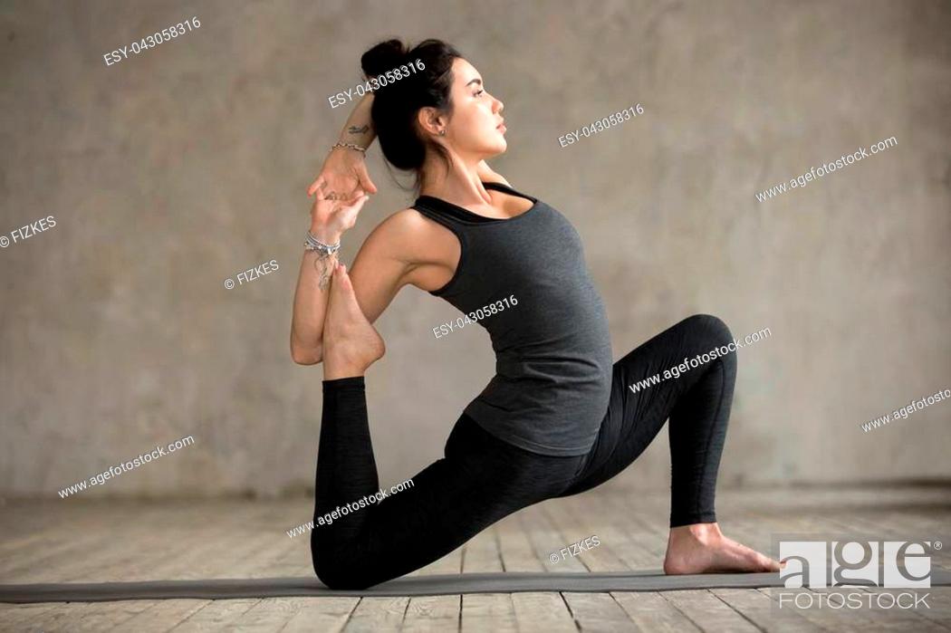 Stock Photo: Young woman practicing yoga, doing anjaneyasana exercise, Horse rider pose, working out, wearing sportswear, black pants and top, indoor full length.