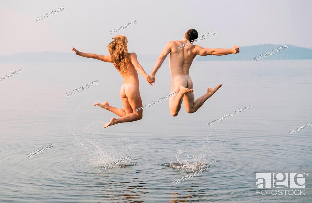 Naked couples have fun playing with ball on the beach
