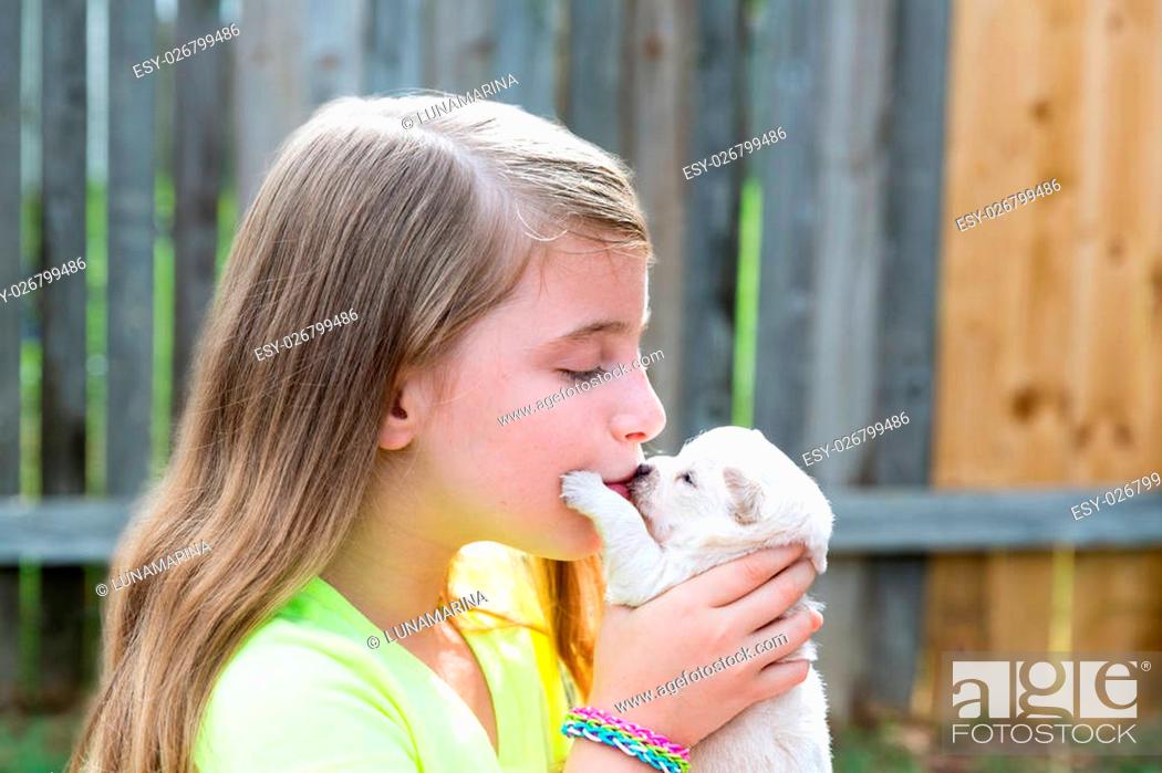 Stock Photo: Blond kid girl kissing puppy pet chihuahua playing happy with doggy outdoor.