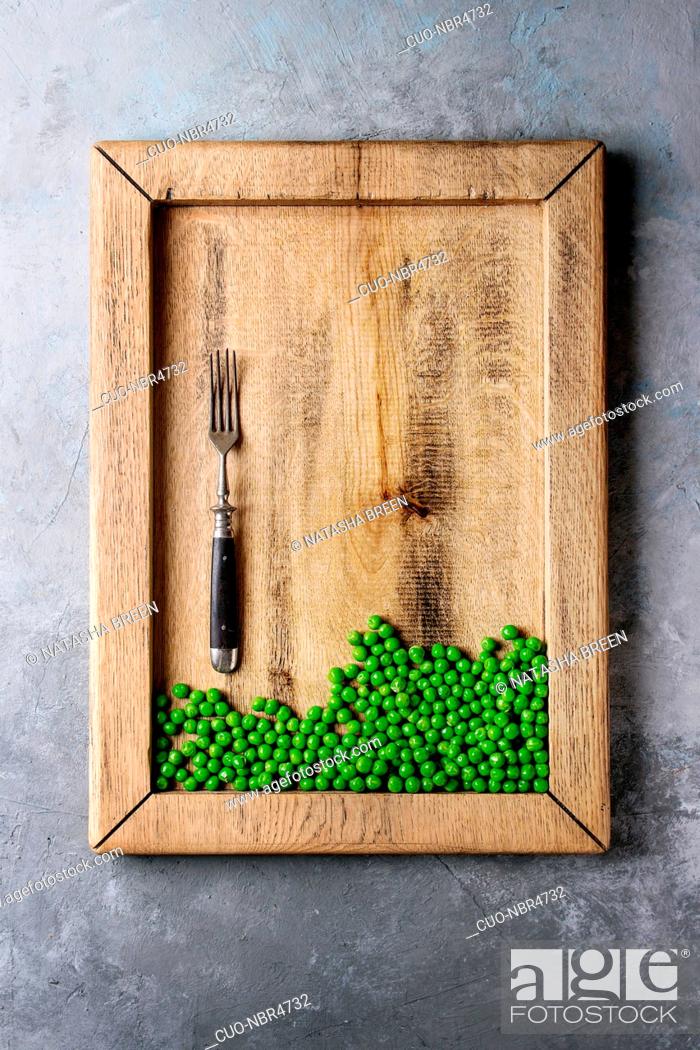 Stock Photo: Raw uncooked organic green pea in wooden tray with fork over grey texture background. Top view, space. Diet concept.