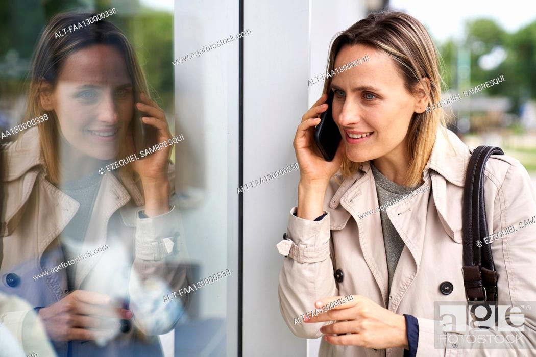 Stock Photo: Medium shot of woman and her reflection on shop window.