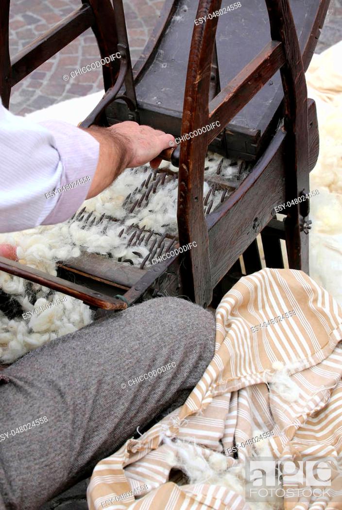 Stock Photo: Elder carder while carding wool or cotton with old wooden machine to make the cushions and mattresses.