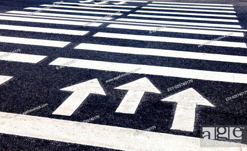 Stock Photo: Zebra crossing with white marking lines and direction of motion on asphalt.