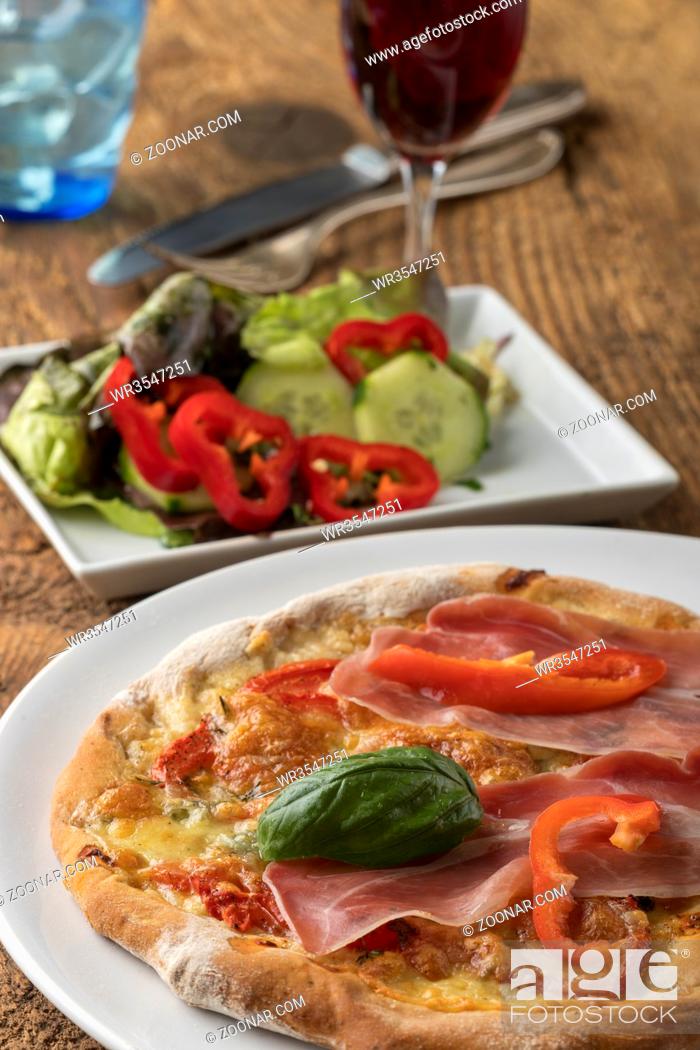 Stock Photo: Detail einer Pizza mit Schinken und Basilikum.