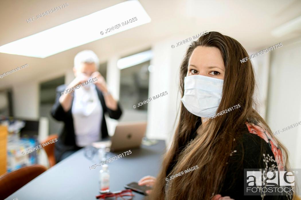 Imagen: Woman in office wearing face mask.