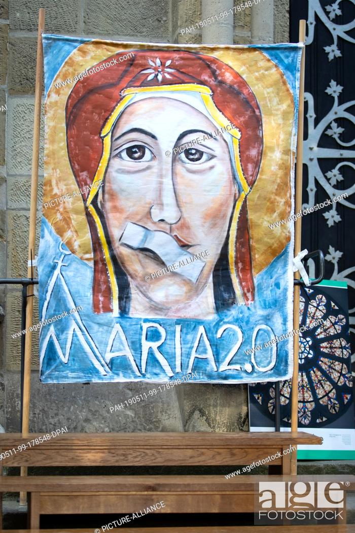 Stock Photo: 11 May 2019, North Rhine-Westphalia, Münster: A banner shows Mary, the Mother of God, with a plaster on her mouth during an open-air service.