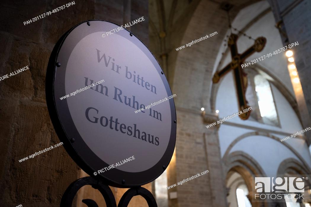 Stock Photo: 27 November 2020, Lower Saxony, Osnabrück: ""We ask for quiet in the house of God"" is written on a signpost in St. Peter's cathedral.