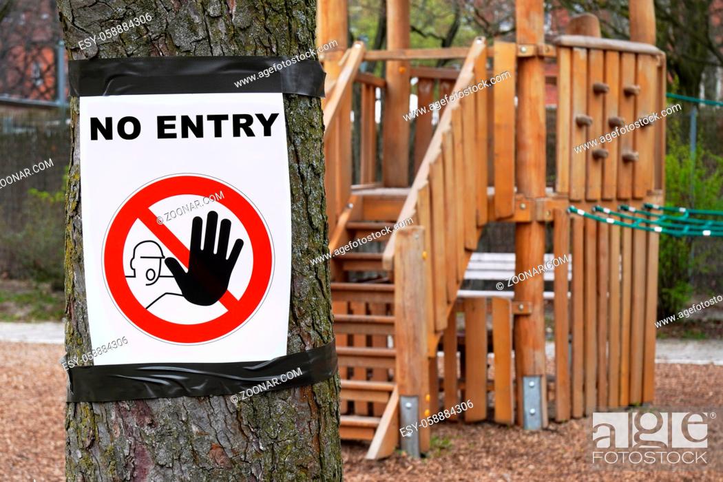 Stock Photo: Closed playground with no entry prohibition sign as social distancing measure during corona epidemic crisis.