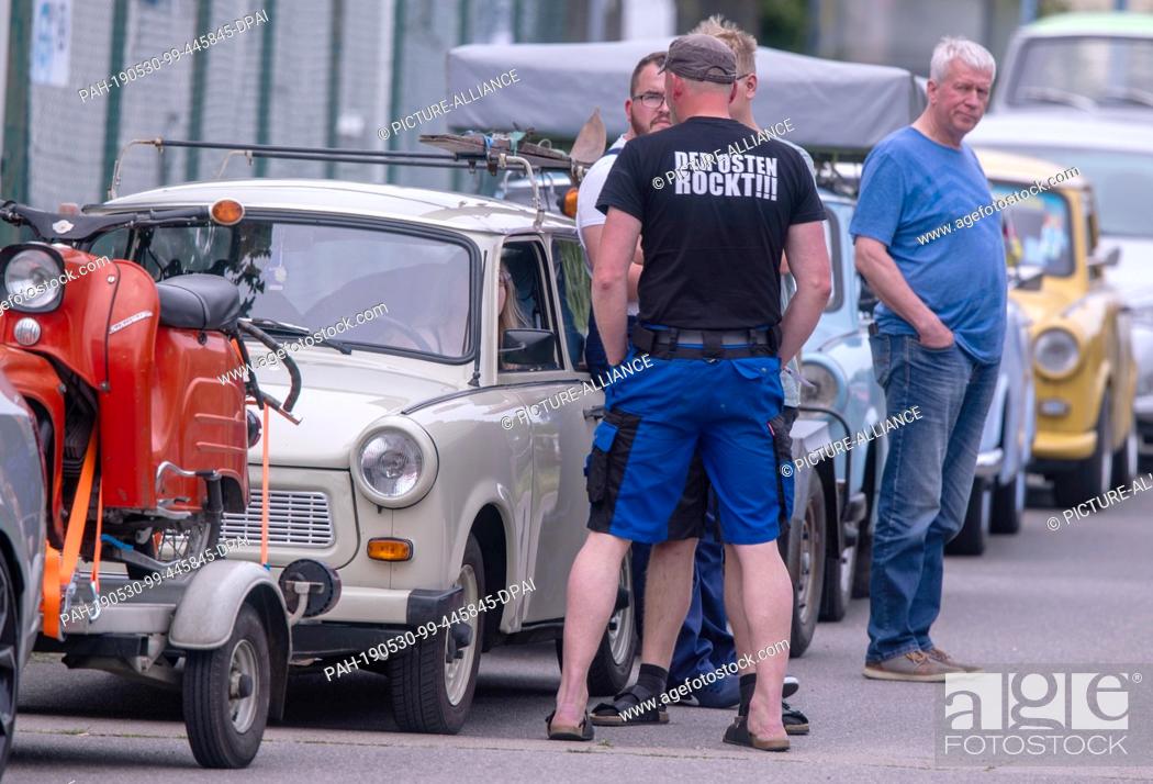 Stock Photo: 30 May 2019, Mecklenburg-Western Pomerania, Anklam: Trabi fans wait with their vehicles in front of the entrance to the grounds of the 25th International Trabi.
