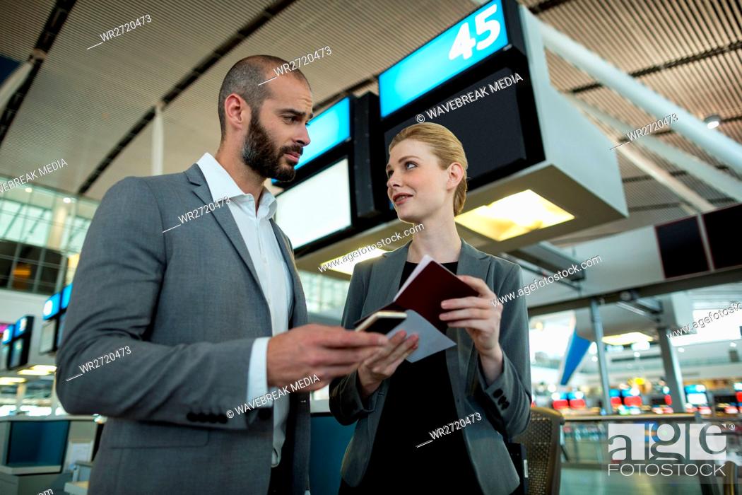 Stock Photo: Business people holding boarding pass and using mobile phone.